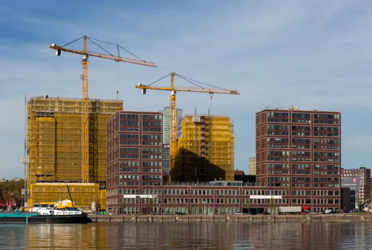 Bouwkranen boven nieuwbouw aan het water